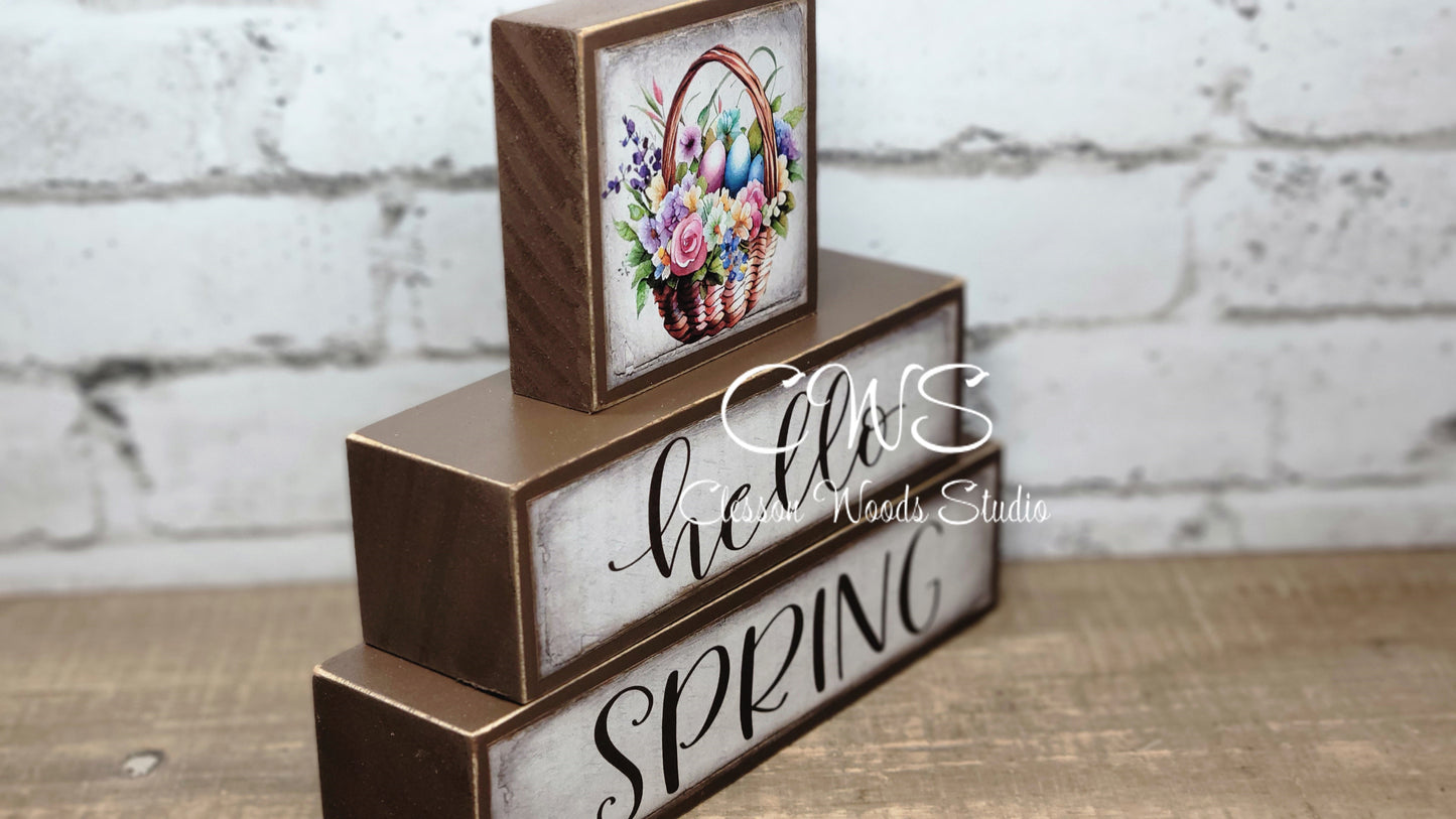 Hello Spring Basket of Flowers and Colored Eggs Brown Wood Block Stack